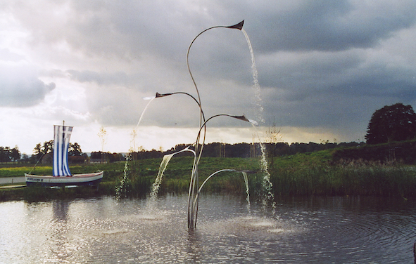 Designer Springbrunnen mit Wasserspiel im Wasser am See und Uferpromenade